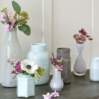 flower vases on grey table and white wall