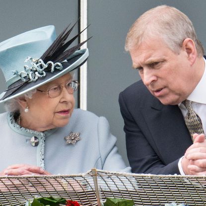 Queen Elizabeth wearing a light blue hat and coat talking to ex-Prince Andrew leaning over a railing