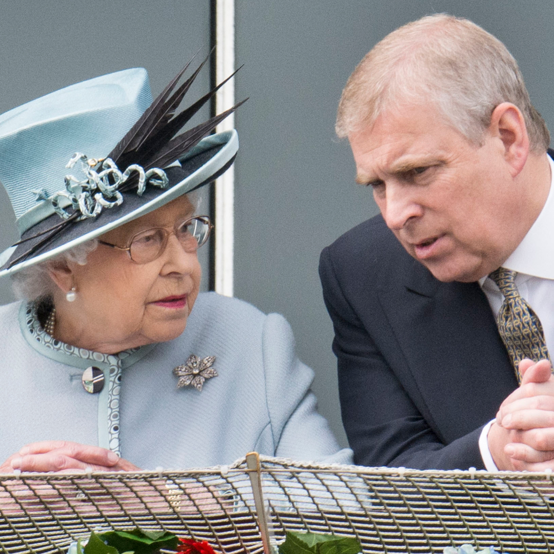 Queen Elizabeth wearing a light blue hat and coat talking to ex-Prince Andrew leaning over a railing