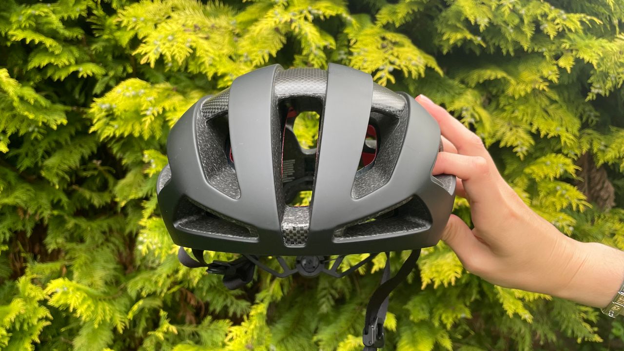 Female cyclist holding the Trek Velocis MIPS road bike helmet