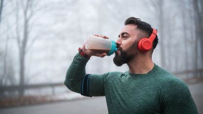 Man drinking a protein shake outside