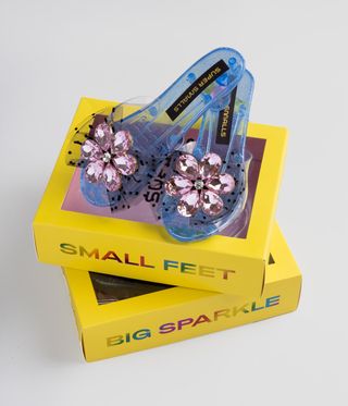 Plastic kids shoes on a yellow box