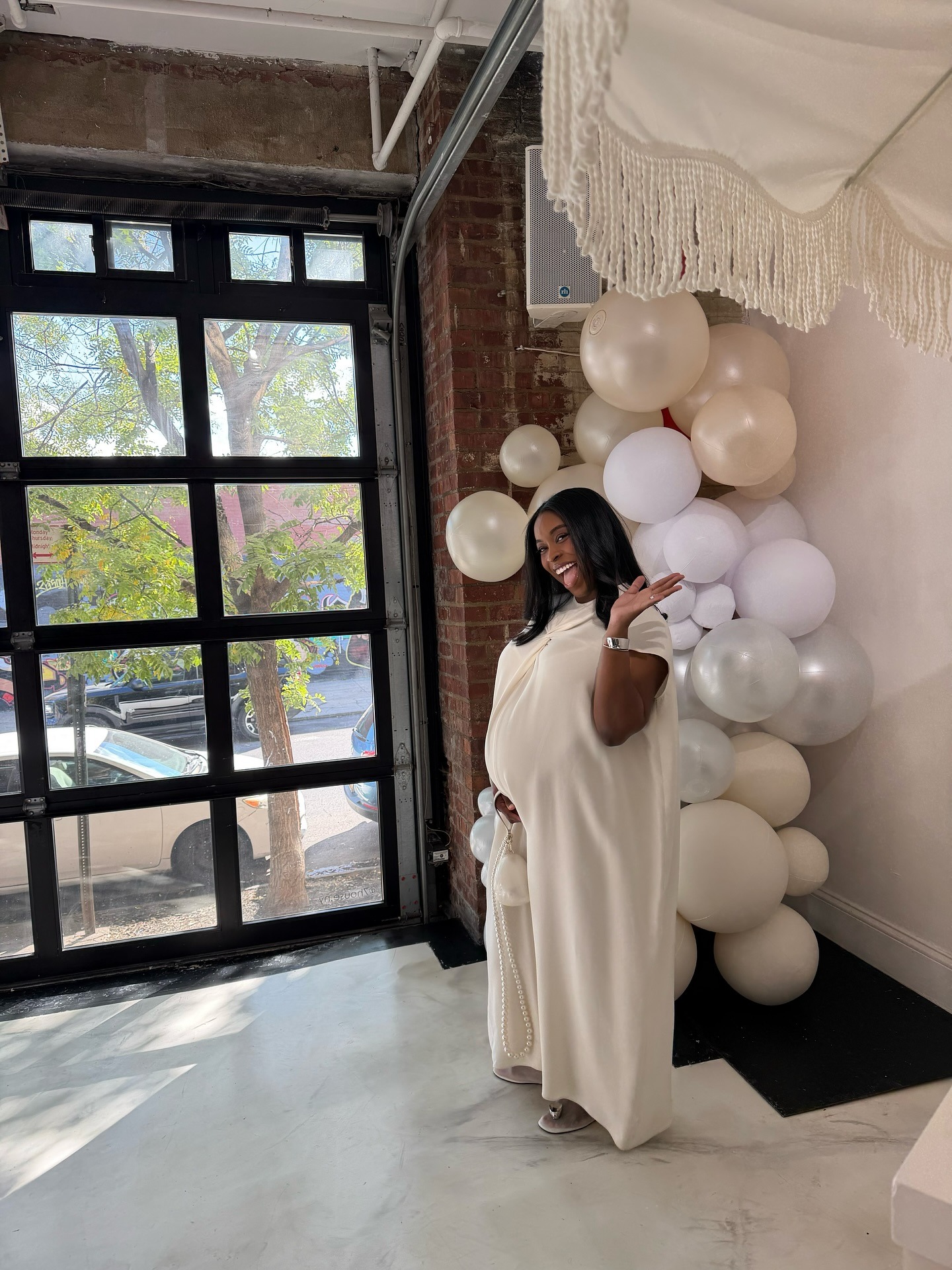 Photo of mother wearing white maternity dress.