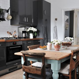 kitchen area with black cabinet and dining table