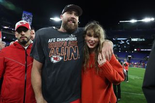 Taylor Swift and Travis Kelce on the football field at the 2024 AFC Championships. Taylor wears an oversize sweater