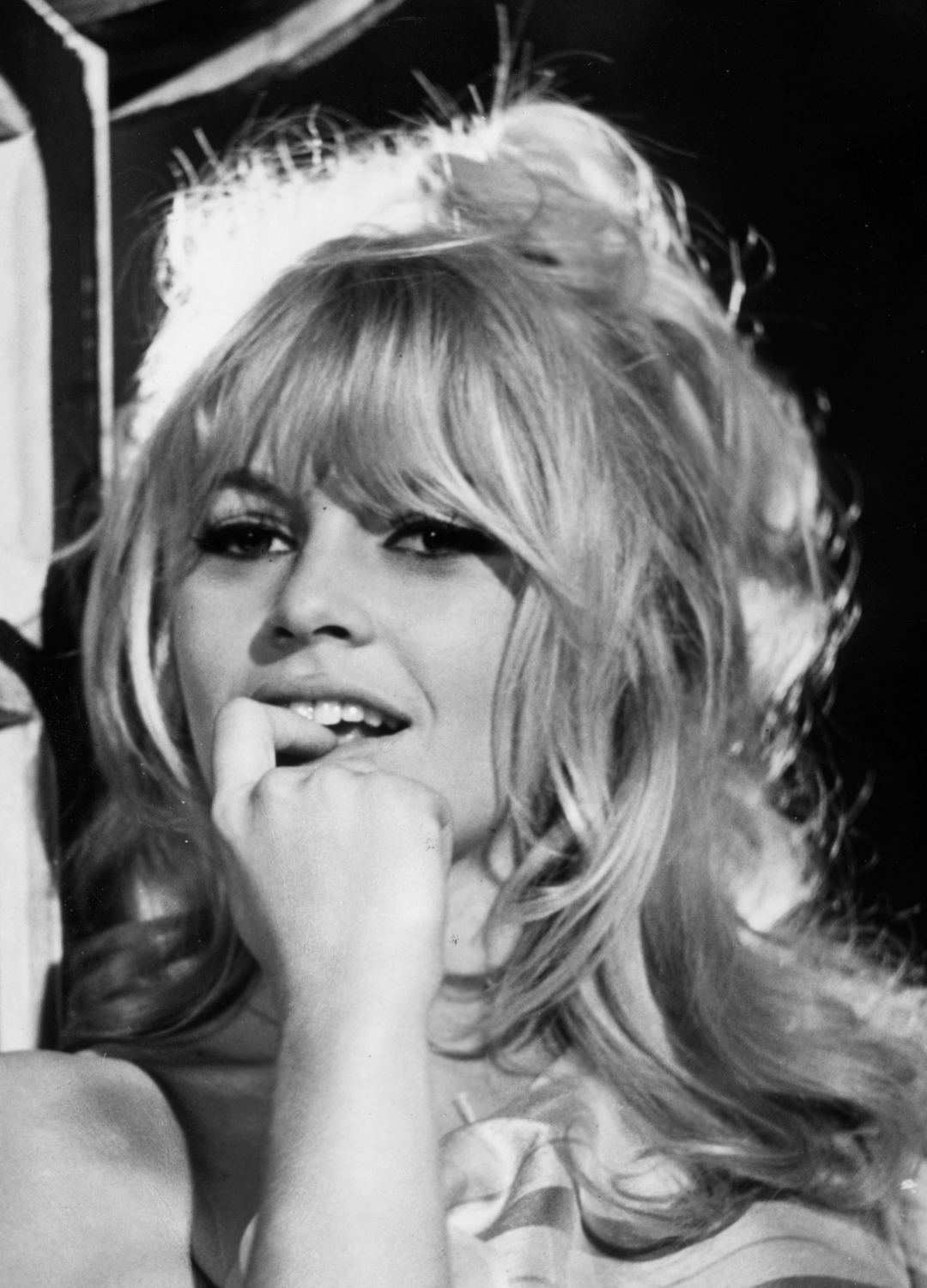 Brigitte Bardot leaning against window panes with her finger in her mouth on the set of director Louis Malle&#039;s film, &#039;Viva Maria!&#039;.