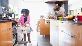 father and daughter loading integrated dishwasher