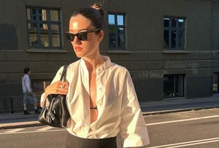 @iliridakrasniqi wearing a white button-down shirt tucked into a double-layer black pencil skirt with sandals and a black purse.