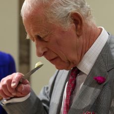 King Charles sniffing cheese on the edge of a knife