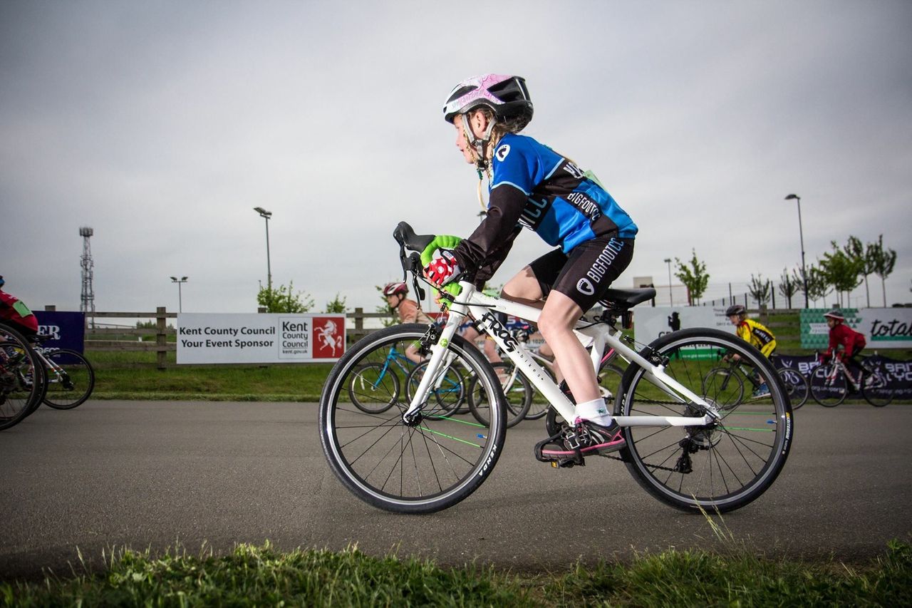 A child racing on a white Frog road bike