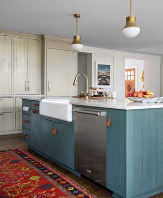 Kitchen with blue island with two types of leather cabinet hardware