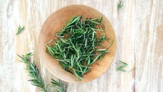 rosemary in a bowl on a wooden table