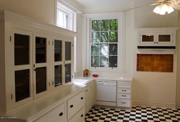 A kitchen in all white and black&white flooring