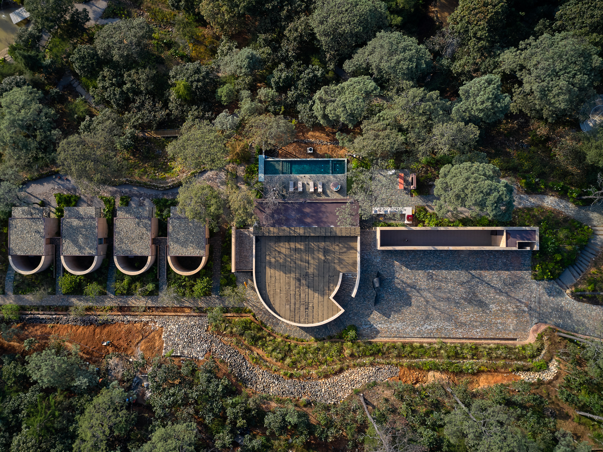 A drone&#039;s eye view showing the arrangement of the four sleeping pavilions, the main living pavilion and the service area at the right