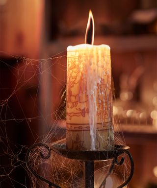 Interior of the Hocus Pocus Airbnb - A candle from the movie with a black flame on a candle stand with cobwebs