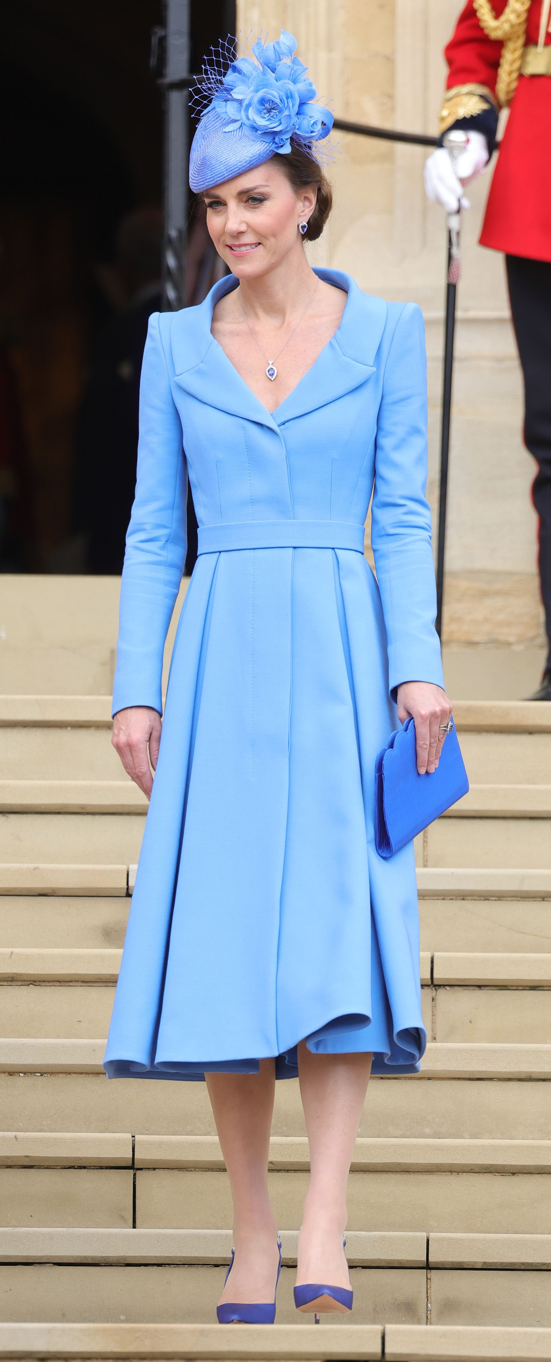Princess Kate wearing a blue coat dress on a staircase