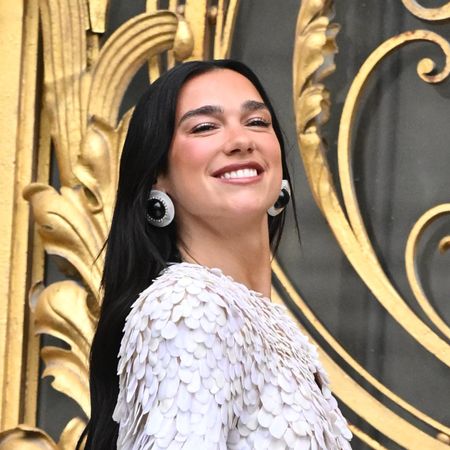 a woman with long black hair in a textured jacket