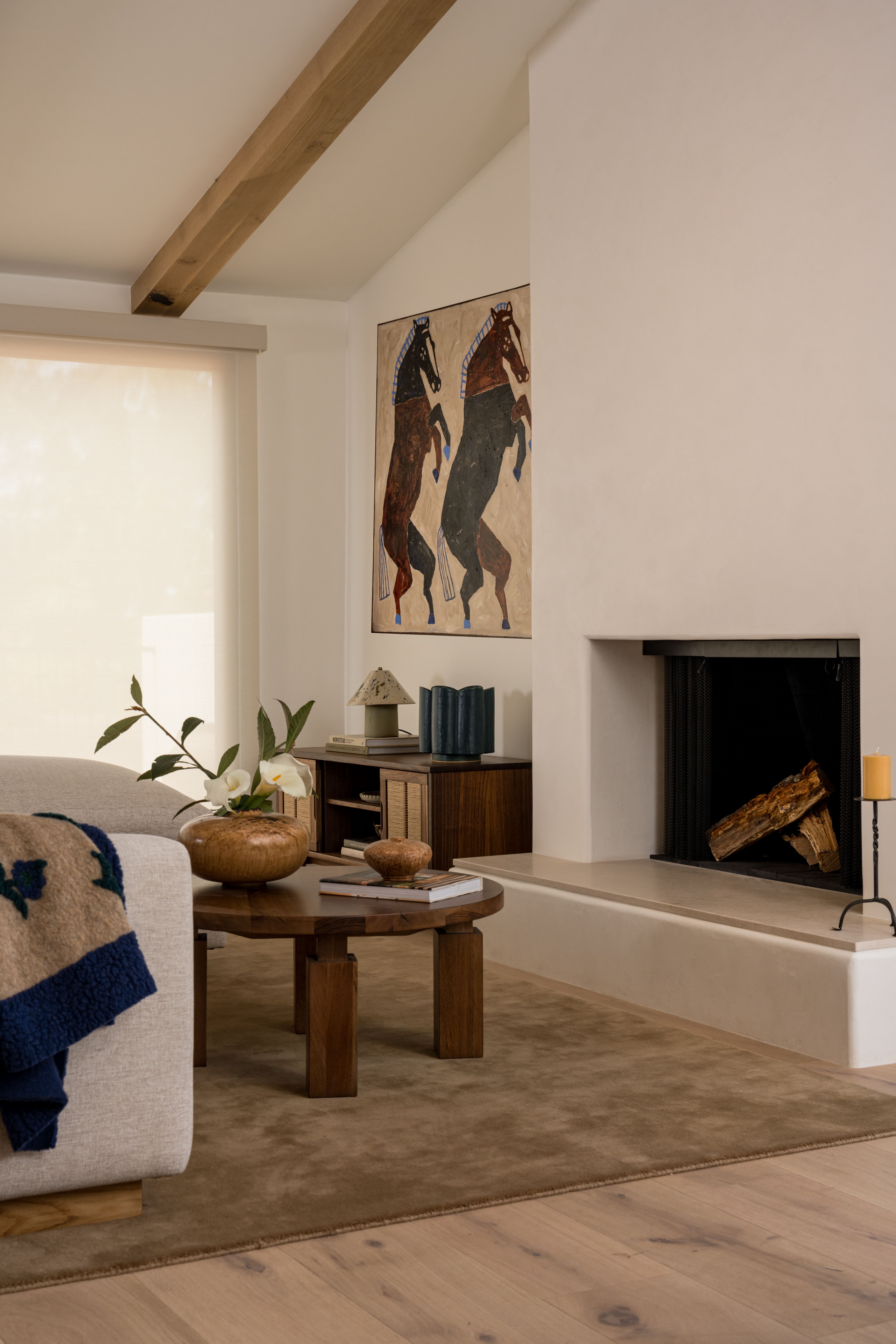 Moden fireplace with over sized beige floor rug and a wood coffee table