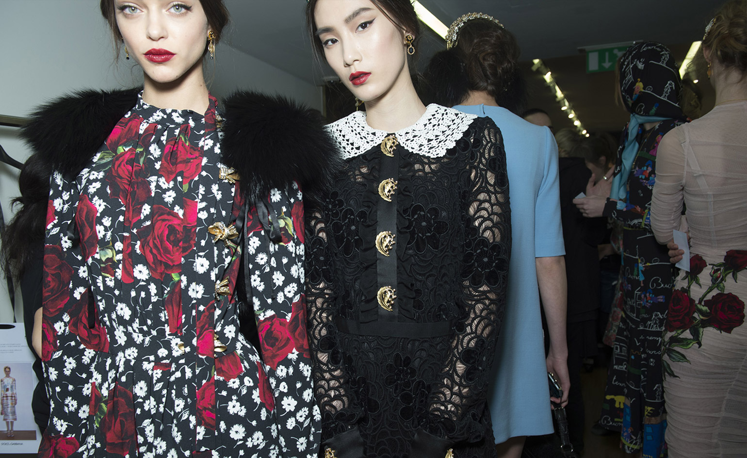 Models wearing a black lace dress and a bold floral patterned dress, from Dolce & Gabbana A/W 2015 collection.