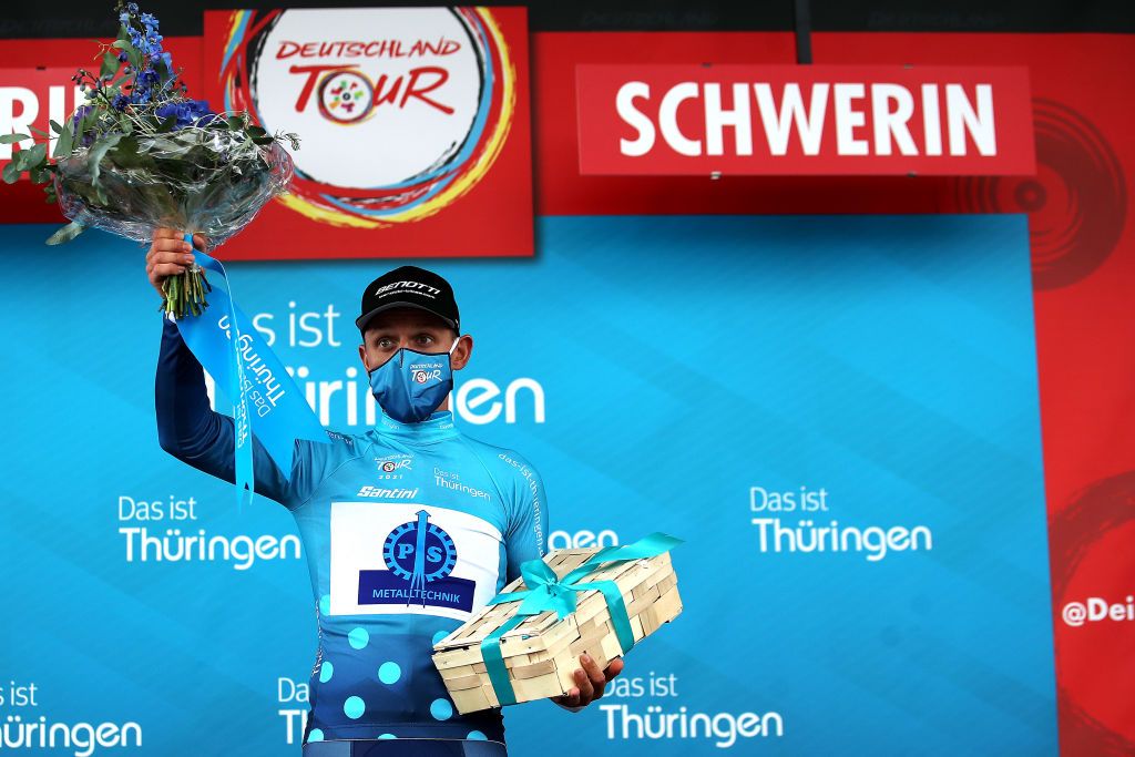 SCHWERIN GERMANY AUGUST 26 Robert Jgeler of Germany and Team P S Metalltechnik celebrates winning theBlue Mountains Jersey on the podium ceremony after the 35th Deutschland Tour 2021 Stage 1 a 191km stage from Stralsund to Schwerin DeineTour on August 26 2021 in Schwerin Germany Photo by Christian KasparBartkeGetty Images