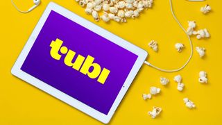 Tubi on a tablet with headphones and popcorn nearby