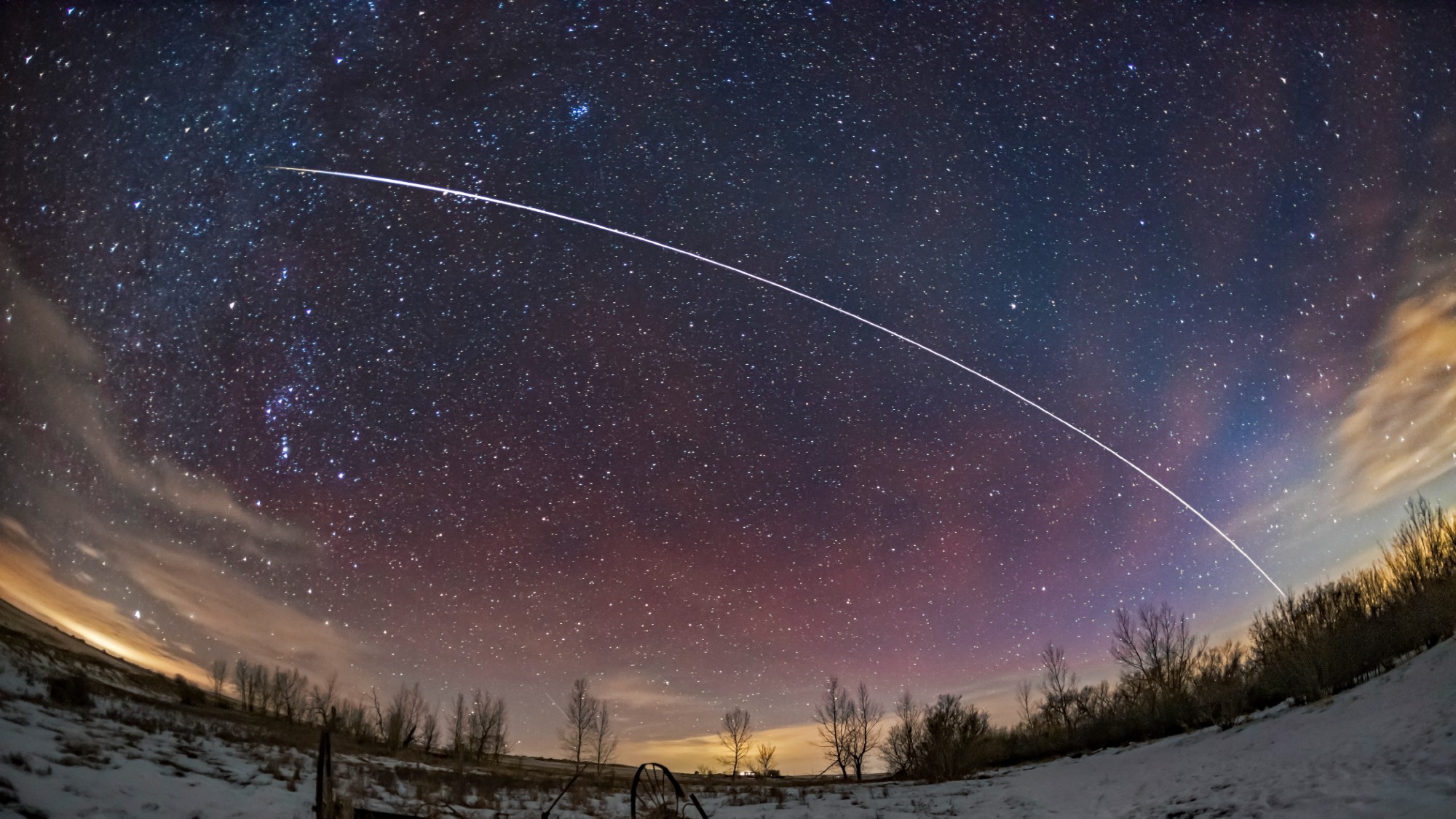 a streak of light arcs across the night sky