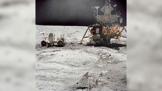 Astronaut John W. Young, Apollo 16 lunar landing mission commander, prepares the Lunar Roving Vehicle for traversing the surface of the moon.