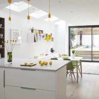 kitchen with white wall white counter shelving units and glass door