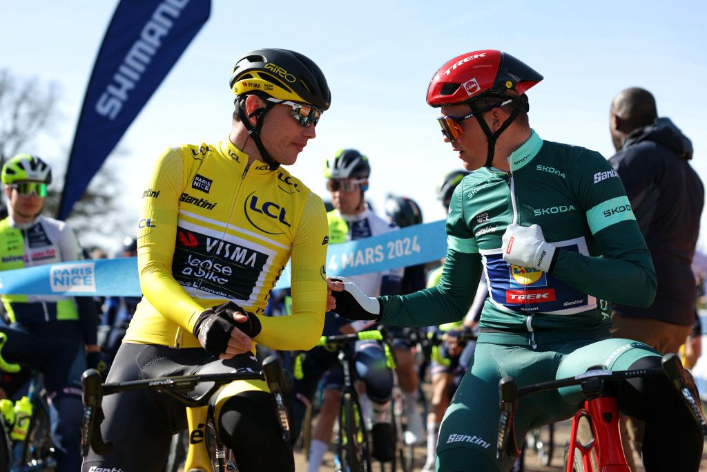 Team Visma-Lease a Bike's Dutch cyclist Olav Kooij (L), wearing the overall leader yellow jersey, speaks with Lidl-Trek's Danish cyclist Mads Pedersen prior to the start of the 2nd stage of the Paris-Nice cycling race, 179 km between Thoiry and Montargis, on March 4, 2024. (Photo by Thomas SAMSON / AFP)
