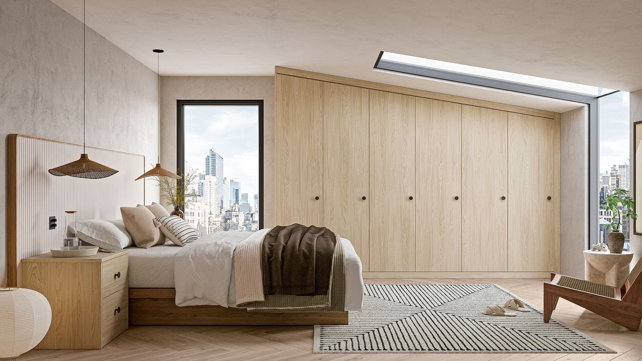 White bedroom with wooden fitted wardrobe along one wall