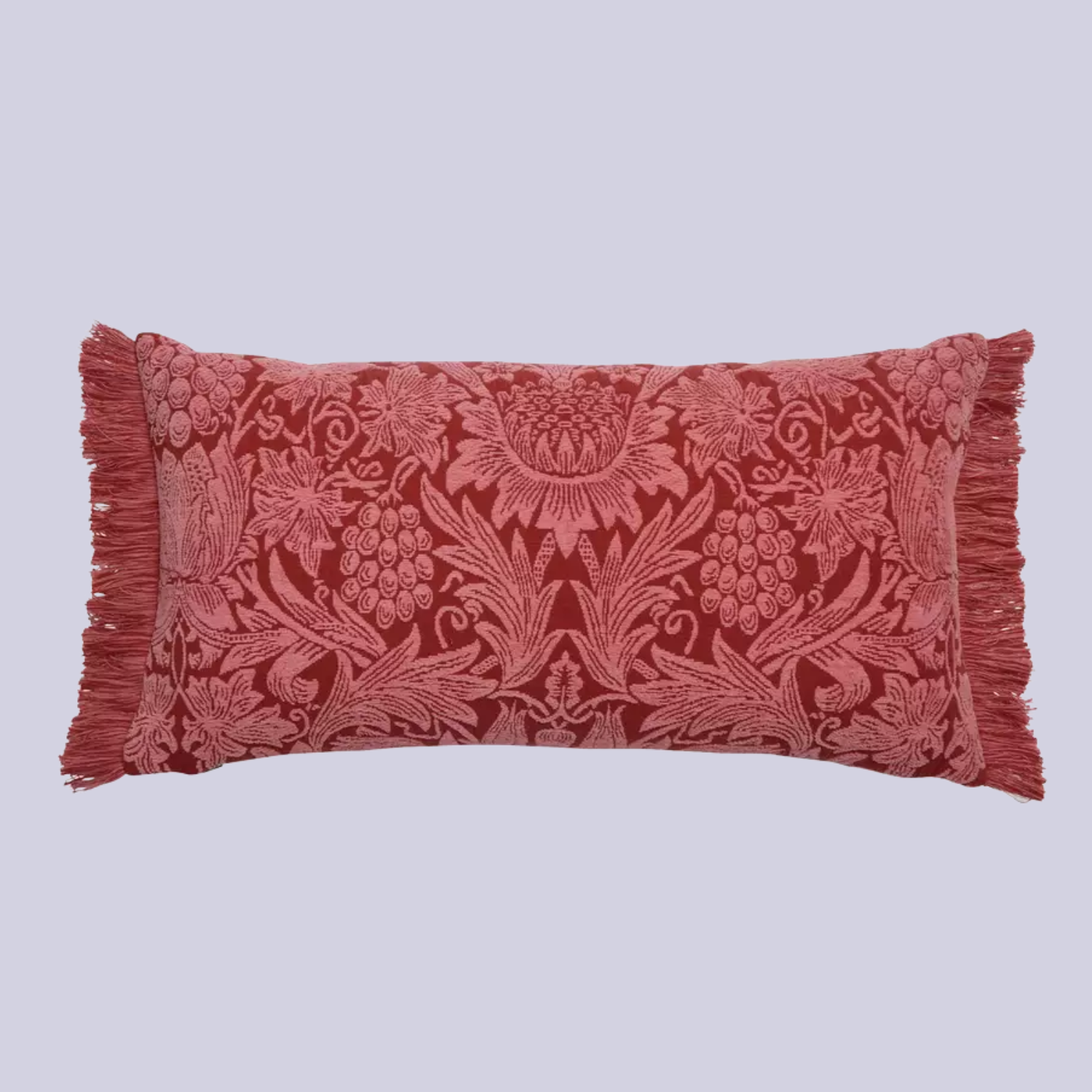 A floral patterned rust bolster pillow with fringe hems