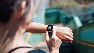 What are cardio heart rate zones? image shows woman looking at heart rate monitor