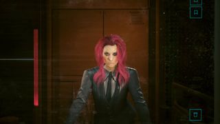 Female V with pink hair wearing a suit standing in front of the mirror in Cyberpunk 2077.