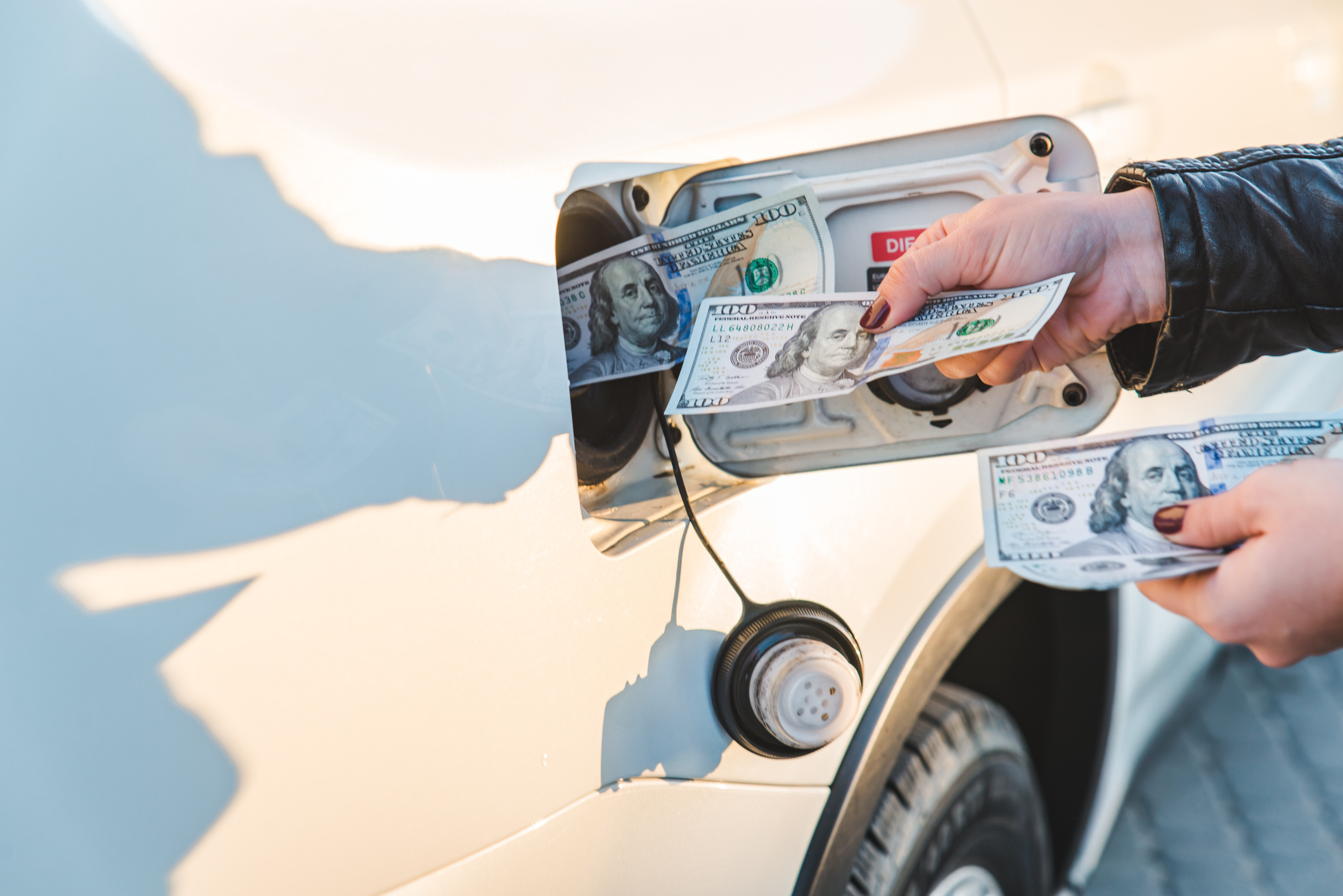 Woman put money to car tank. 
