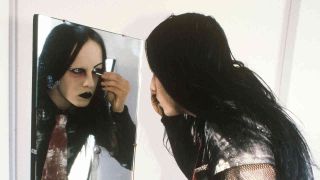 Joey Jordison applying make up in a mirror