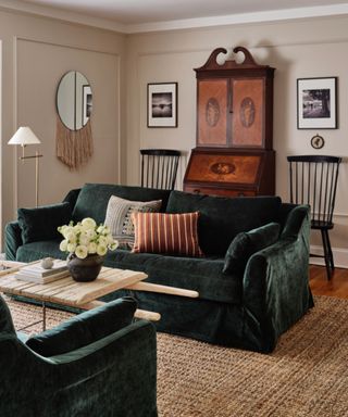 ryann swan design living room with neutral walls and a green velvet couch