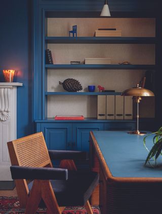 A home library with blue painted shelving