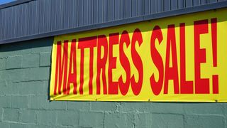 A banner on a wall saying 'MATTRESS SALE!'