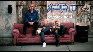 Spinal Tap sitting in a sofa on a pavement