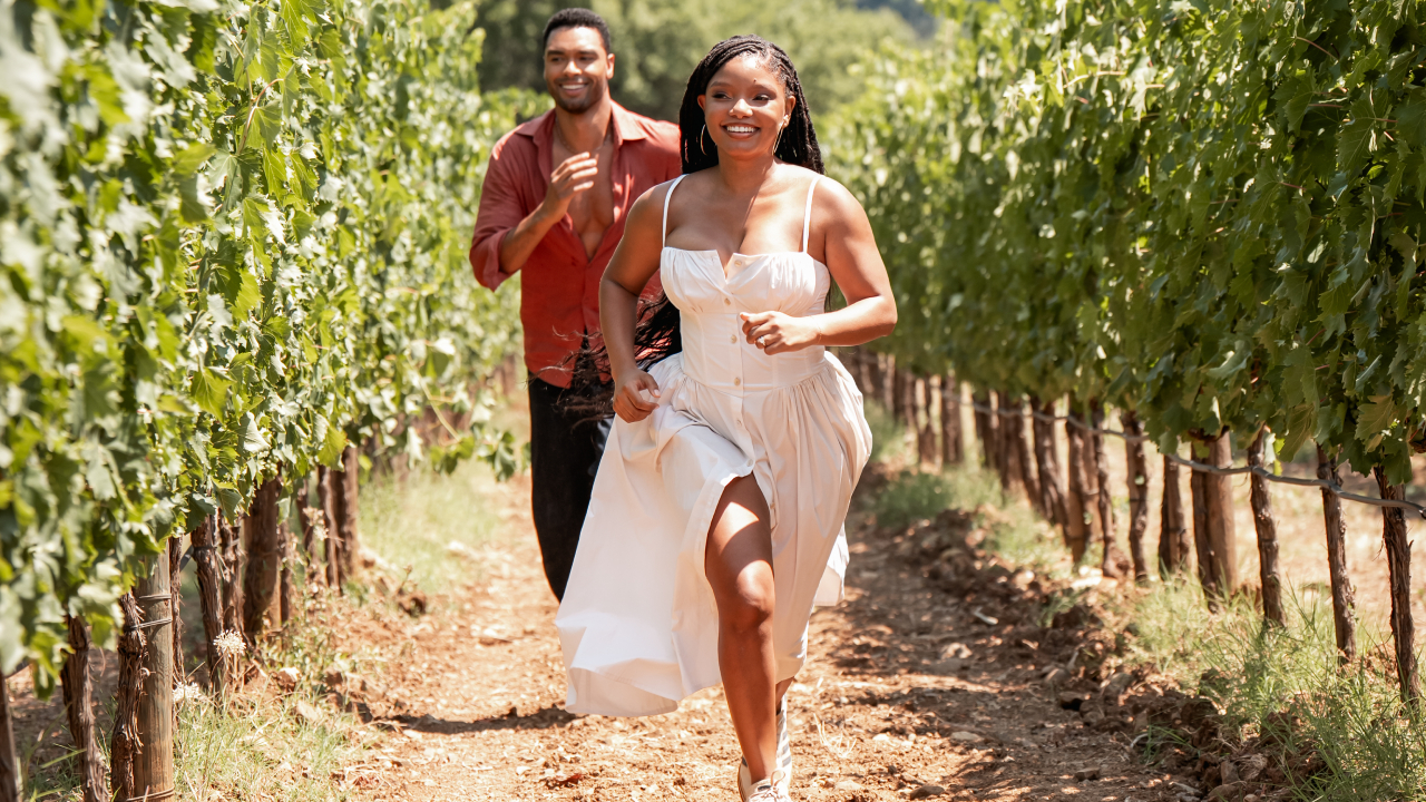 Reg&eacute;-Jean Page and Halle Bailey running through the fields in You, Me &amp; Tuscany.
