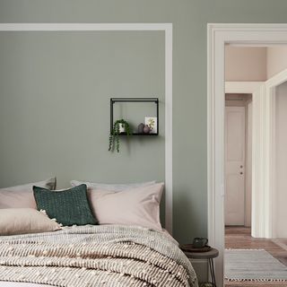 Neutral toned bedroom with green painted wall