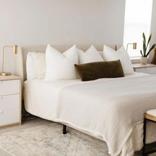 White bed frame in white bedroom