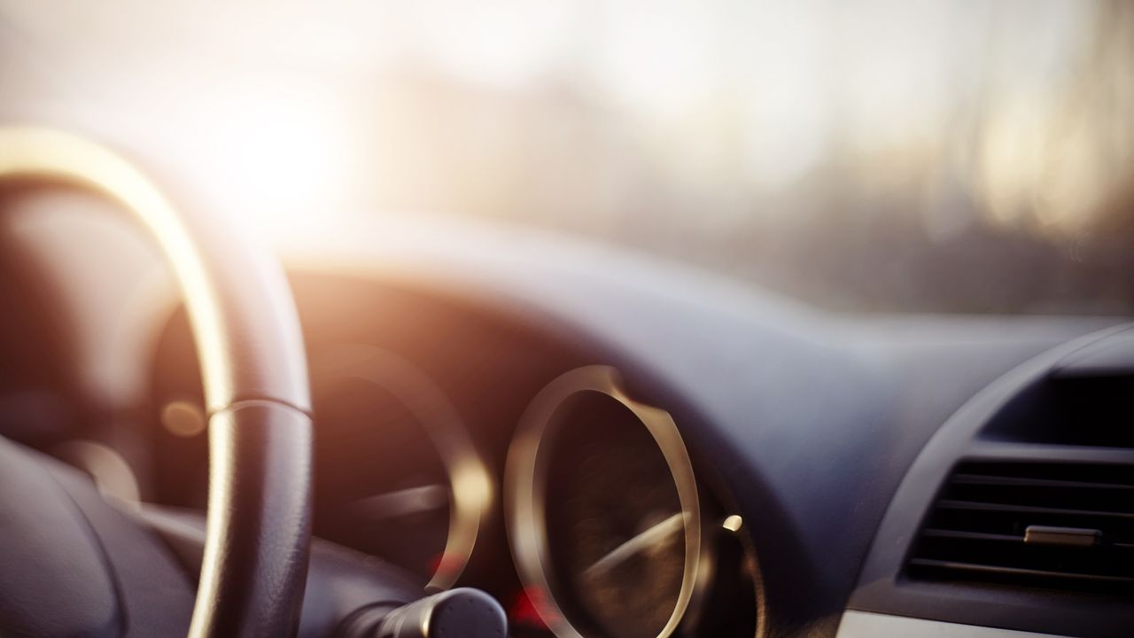 The steering wheel and dashboard of a car.