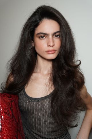 A model backstage at 16Arlington SS25 wearing bombshell blowout, a key Spring/Summer 2025 Fashion Month Beauty Look