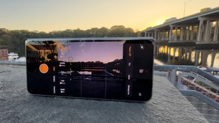 OnePlus Open med kamera-app åben peger på en bro ved solopgang