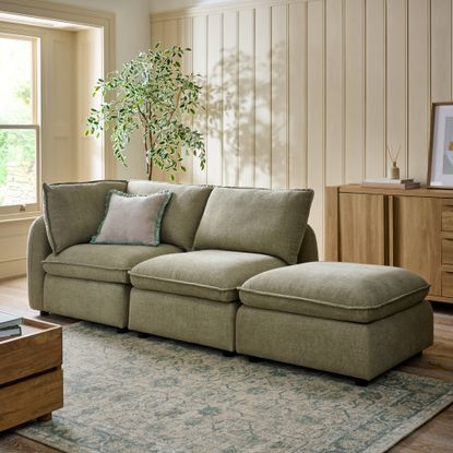 Next Crosby modular storage sofa in light olive in a wall-panelled living room