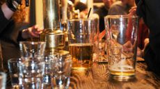 Half empty and nearly empty pint glasses of beer on the bar of a pub