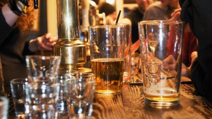 Half empty and nearly empty pint glasses of beer on the bar of a pub