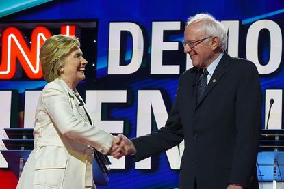 Clinton and Sanders shake hands.