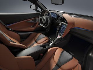 Interior, left-hand drive with light-brown leather seats with dark brown trim. Dashboard is a mixture of dark brown and light brown.